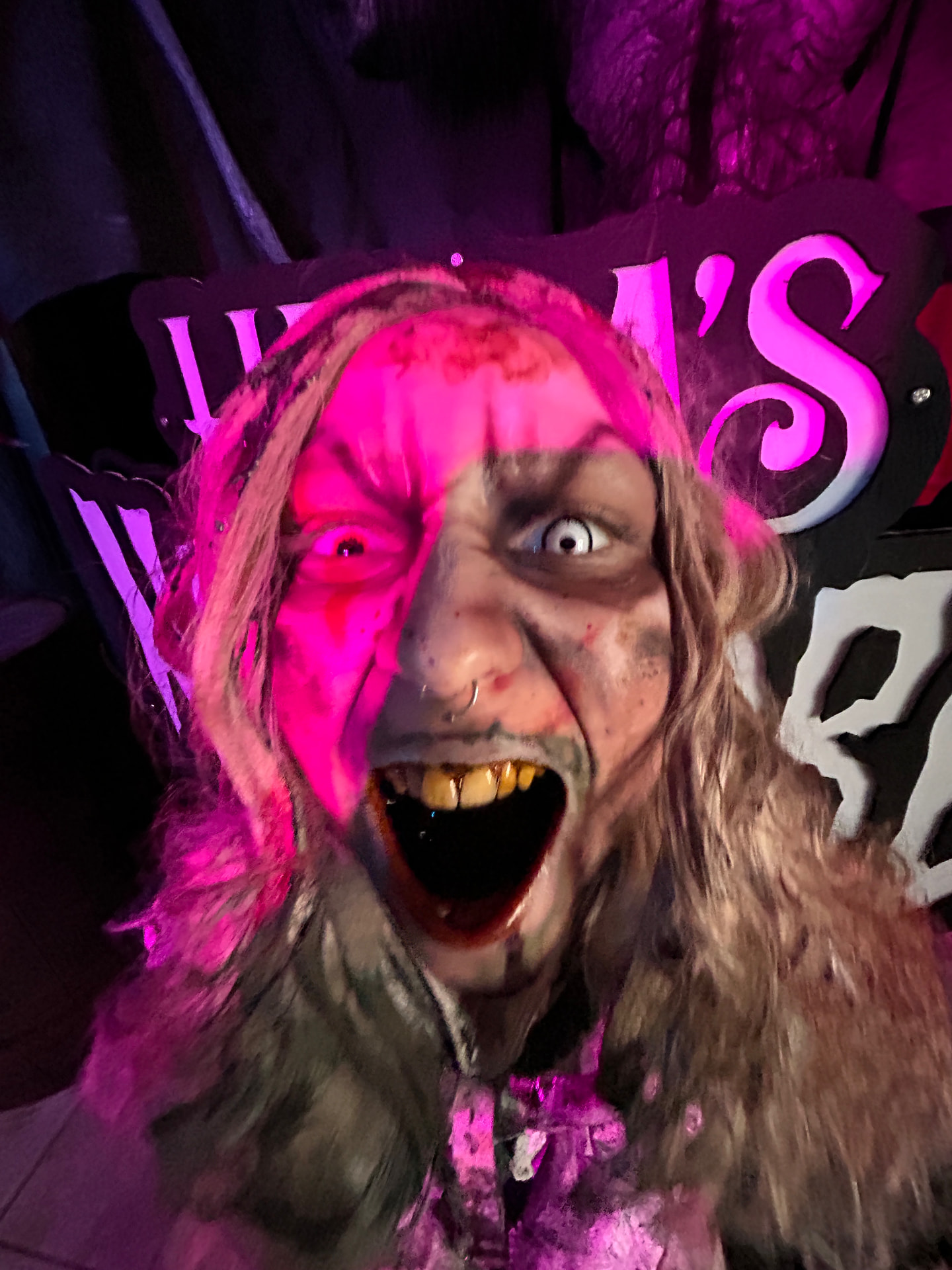 A character screaming under pink light at Hera's Nightmare